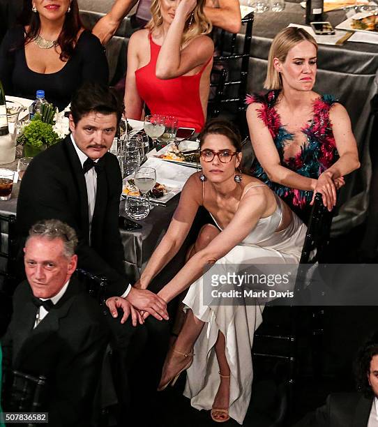 Actor Pedro Pascal and Amanda Peet share an embrace while actress Sarah Paulson looks on during The 22nd Annual Screen Actors Guild Awards held at...