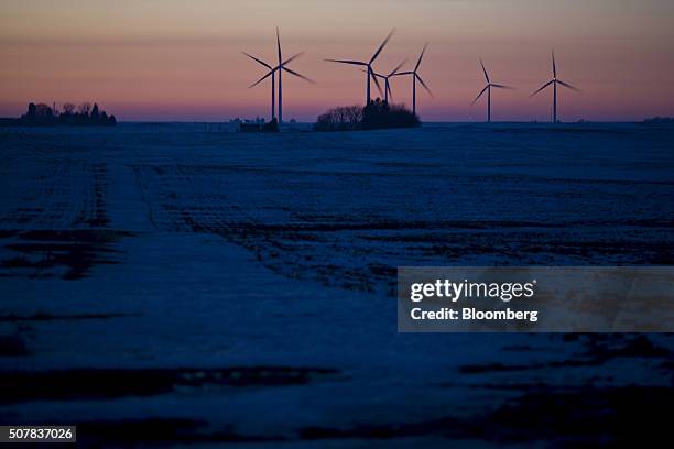 Windmills stand in a snow covered field near Wellsburg, Iowa, U.S., on Sunday, Jan. 31, 2016. Just one day before the first-in-the-nation caucuses,...