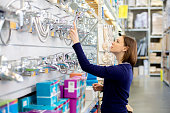 woman looking faucets at plumbing store