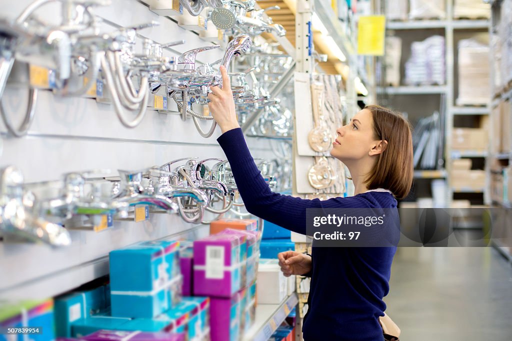 Woman looking faucets at plumbing store