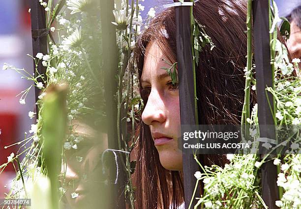 Una nina escucha la misa frente al colegio Agustiniano, en Bogota el 29 de abril de 2004. Un total de 22 ninos y un adulto muertos, asi como una...