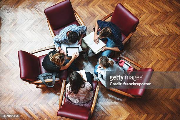 riunione degli studenti in biblioteca-lavoro di squadra - small group of people foto e immagini stock