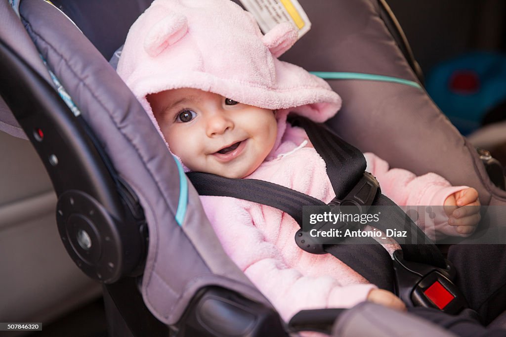 Happy baby girl in a car seat