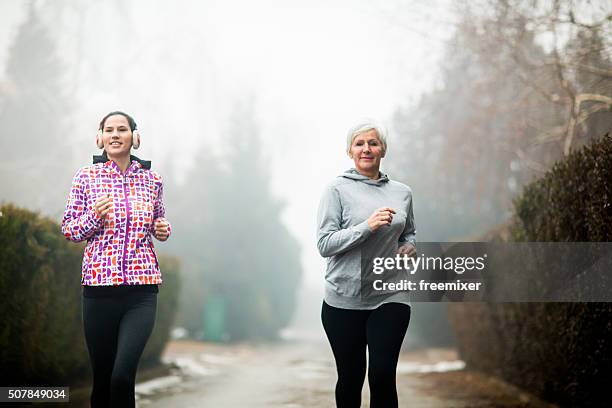 two sporty women - jogging winter stock pictures, royalty-free photos & images