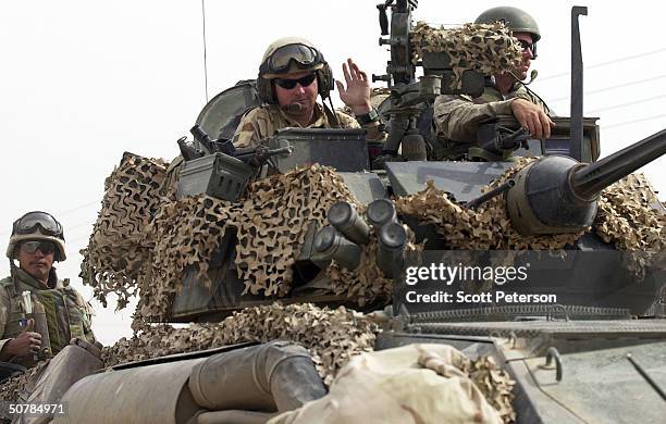 Marine waves from his seat on April 29, 2004 in Fallujah, Iraq. While U.S. Marine commanders hold peace talks, marines ready for battle at their base...