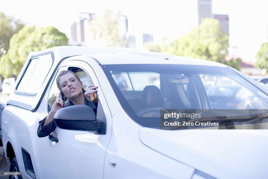 Young businesswoman shouting from car window in city