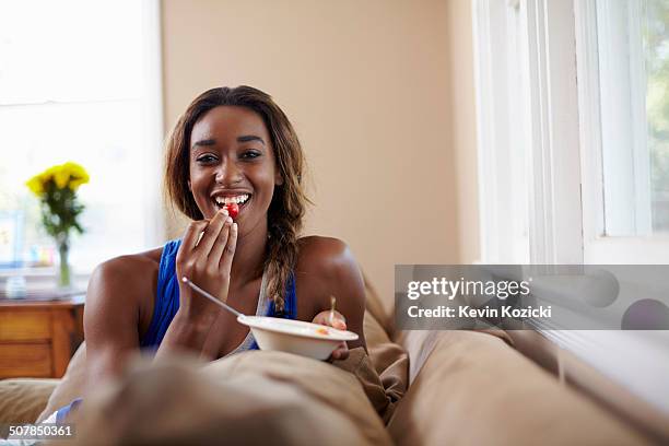 young woman on a training break, eating fruit on sofa - calcio sport imagens e fotografias de stock