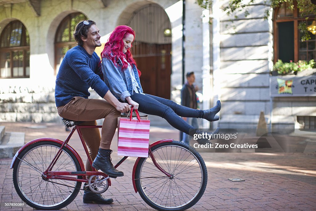 Young woman with sitting on boyfriends bicycle handlebars, Cape Town, South Africa