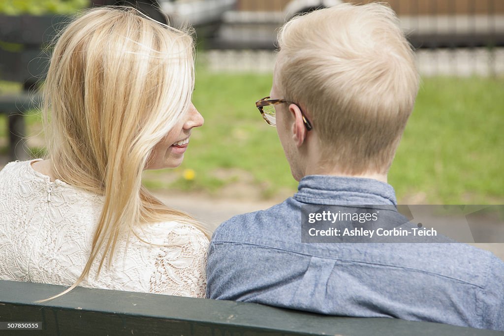 Over the shoulder view of young couple on park bench