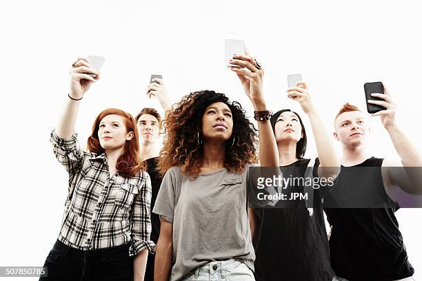 studio portrait of five young adults taking selfies on smartphones - taking selfie white background stock pictures, royalty-free photos & images
