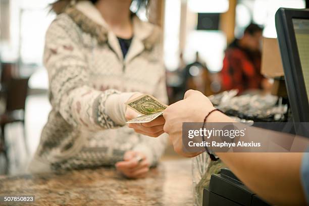 female customer handing payment to waiter over cafe counter - us paper currency stockfoto's en -beelden