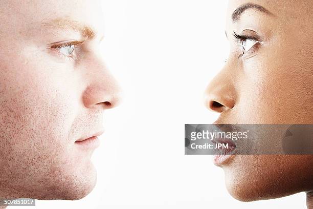 cropped studio portrait of young couple face to face in profile - face to face fotografías e imágenes de stock