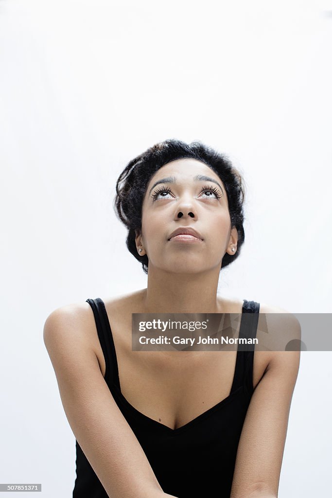 Studio portrait of serene young woman gazing upward