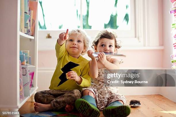 female and male toddler friends pointing and looking up - cuarto de jugar fotografías e imágenes de stock