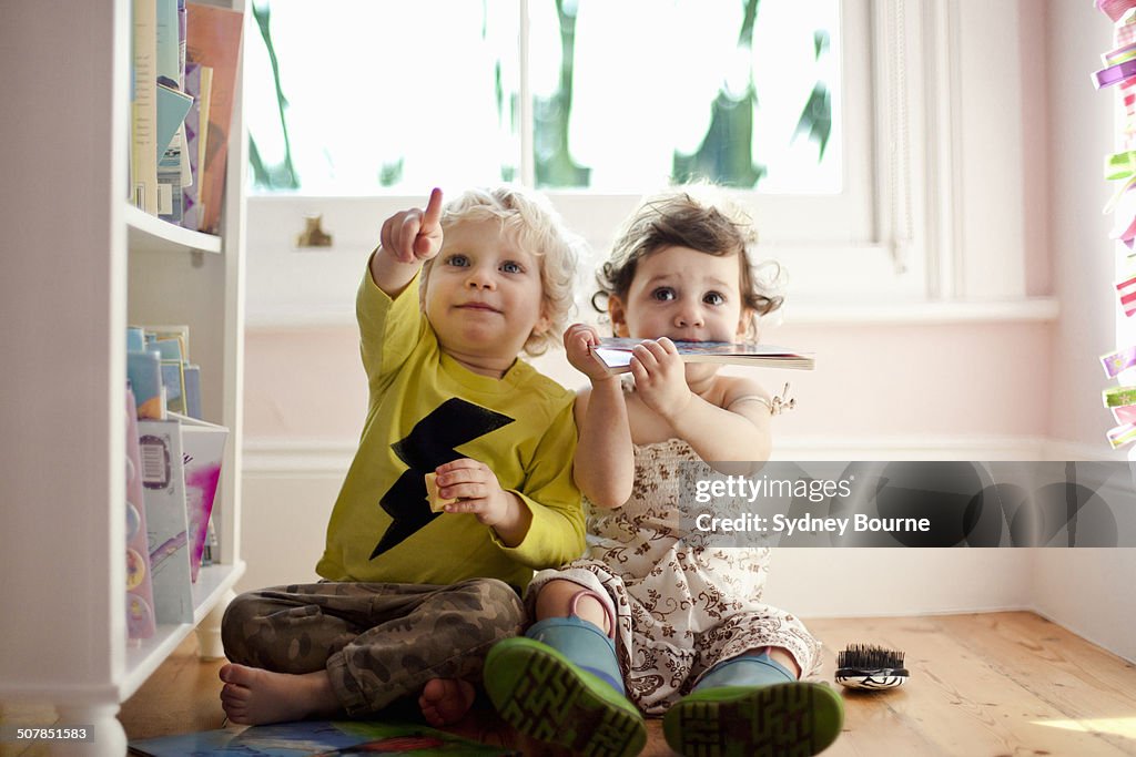 Female and male toddler friends pointing and looking up