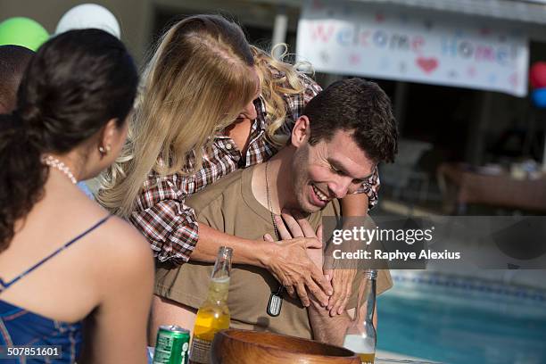 mother hugging mid adult soldier son at homecoming party - familie banner stock-fotos und bilder