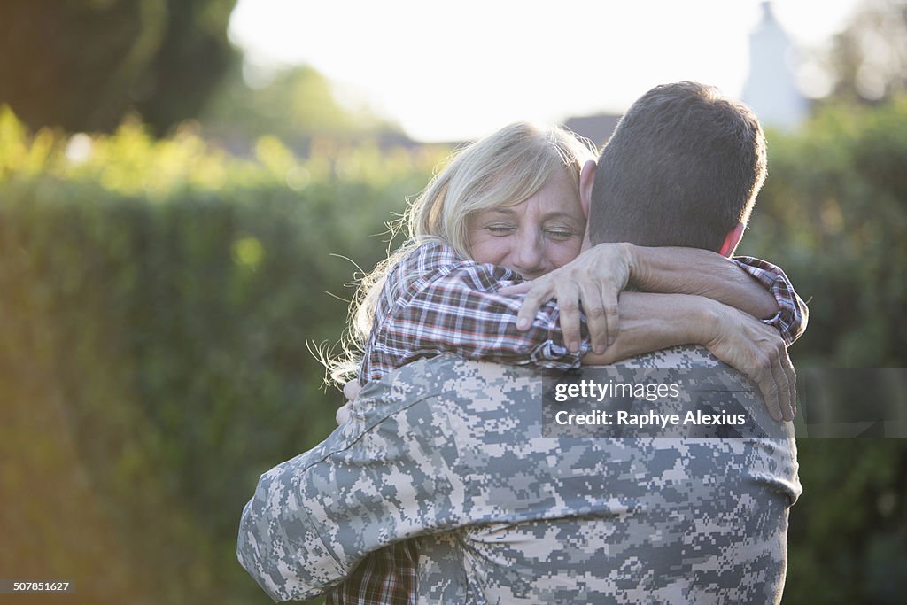 Male soldier hugging mother on street at homecoming