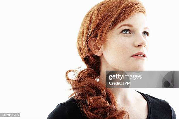 studio portrait of young woman gazing upwards - portrait white background looking away stockfoto's en -beelden