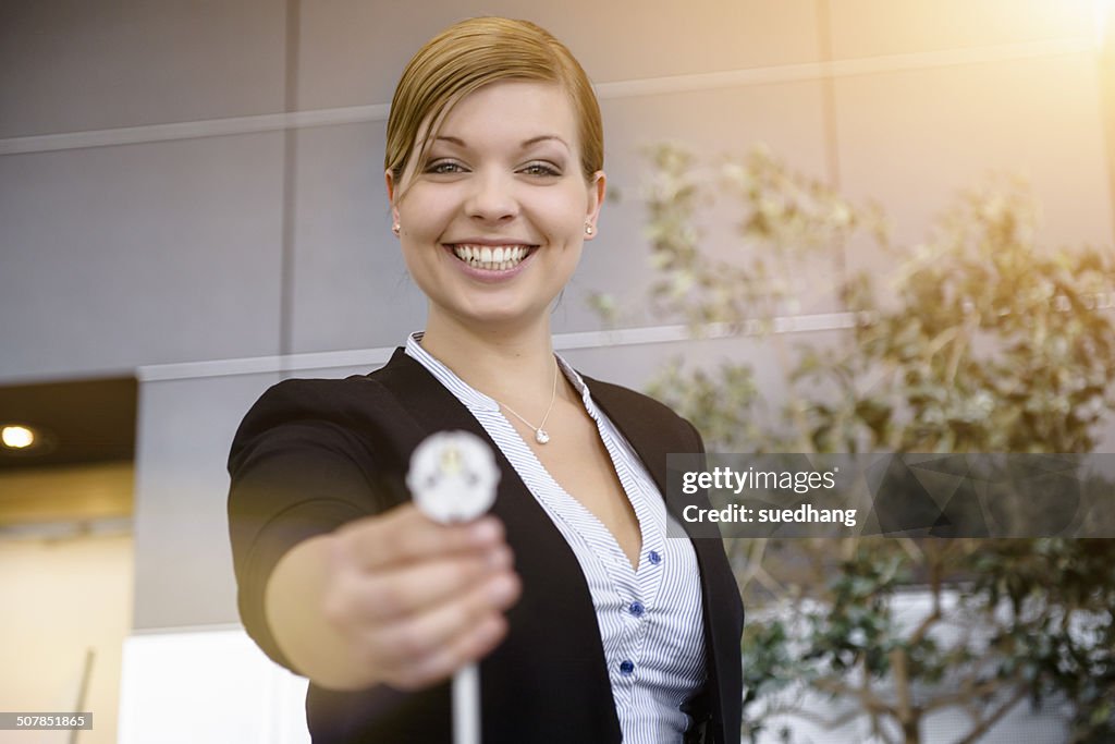 Portrait of young businesswoman holding up cable in office