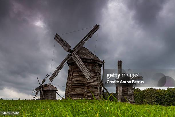 traditional windmill on the background of dramatic sky - molino de viento tradicional fotografías e imágenes de stock