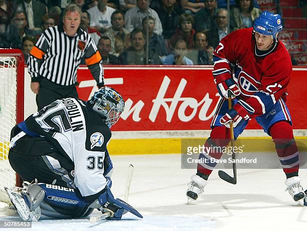 Alex Kovalev of the Montreal Canadiens has his shot stopped as Nikolai Khabiboulin of the Tampa Bay Lightning squeezes the puck between his arm and...