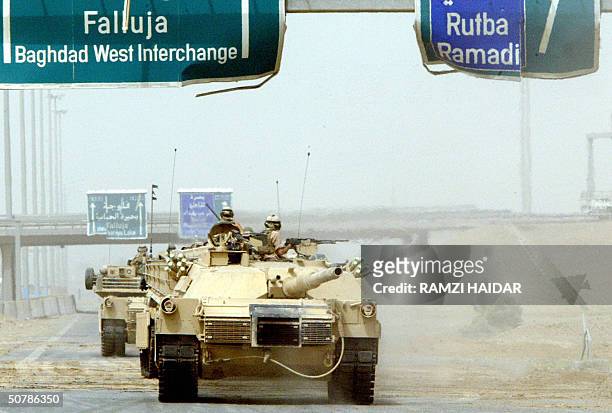 Tanks reposition along the highway linking Baghdad to the restive city of Fallujah 30 April 2004. US forces cleared the highway from razor wires and...