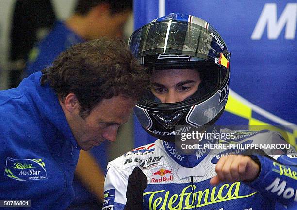 Spanish 250cc rider, Dani Pedrosa gestures as he speaks to his coach Alberto Puig during a free practice session in Jerez, 30 April 2004. AFP PHOTO/...