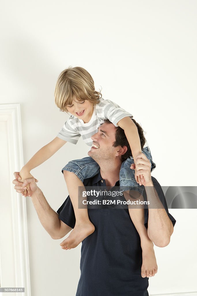 Portrait Of Son Sitting On Father's Shoulder
