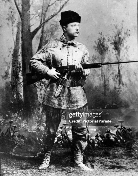 Full-length studio portrait of Theodore Roosevelt , president of the United States from 1901 to 1909, wearing hunting gear and holding a Winchester...