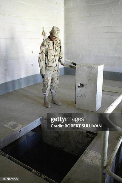 Brigadier General Janis Karpinski pulls the handle releasing the trap door below the gallows of the torture chamber inside the notorious Abu Gharib...