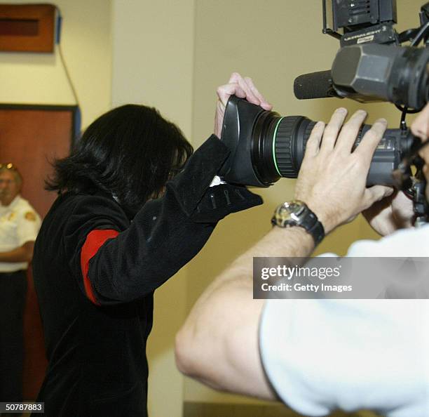 Pop star Michael Jackson covers the lens of a camera to avoid being filmed as he enters the Santa Maria Courthouse April 30, 2004 in Santa Maria,...