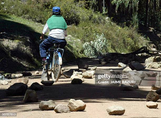 Un poblador elude piedras que bloquean el acceso del poblado de Tilali, distrito del norte de Puno, frontera con Bolivia, el 29 de abril de 2004,...