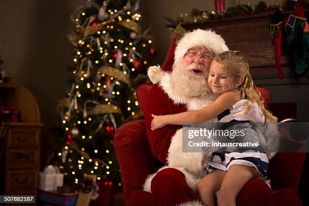 santa claus hugging a child - santa claus stock pictures, royalty-free photos & images