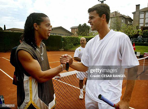 Brazilian soccer player Ronaldinho greets the tennis player Brazilian Gustavo Kuerten, before his match against Argentine Gaston Gaudio. Gaudio won...