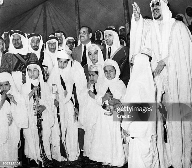 Le roi Ibn Séoud d'Arabie Saoudite assiste à la Mecque, le 19 mars 1954 en compagnie de ses plus jeunes fils armés de sabres et de poignards , à la...