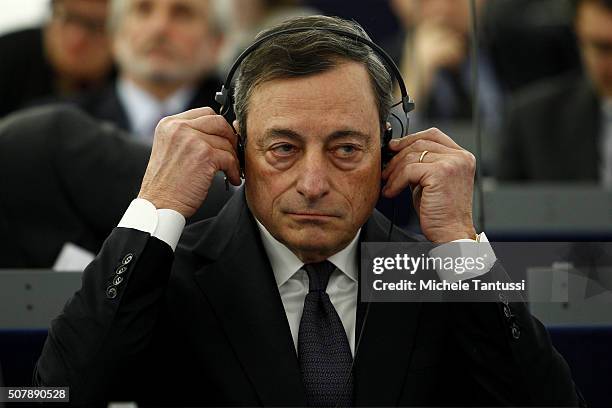 The governor of the European central Bank, or ECB Mario Draghi adjusts his earphones in the plenary room in the European Parliament ahead of the...