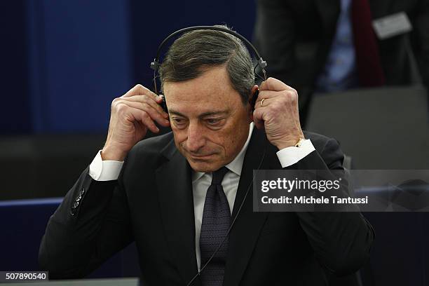 The governor of the European central Bank, or ECB Mario Draghi adjusts his earphones in the plenary room in the European Parliament ahead of the...