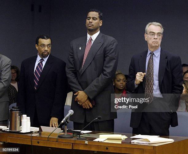 Former NBA player Jayson Williams stands while the verdict is read during his manslaughter trail with his defense attorneys Billy Martin and Joseph...