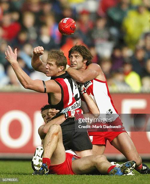 Jared Crouch number 28 and Brett Kirk number 31 for the Swans tackle Jason Johnson number 14 for the Bombers during the round six match between the...