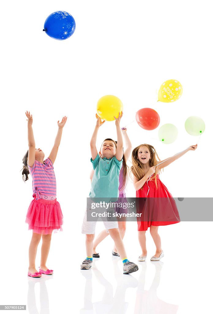 Happy children playing with balloons together.