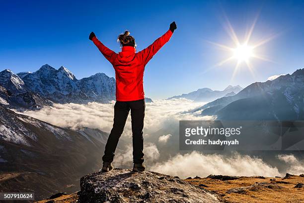 woman lifts her arms in victory, mount everest national park - determination stock pictures, royalty-free photos & images