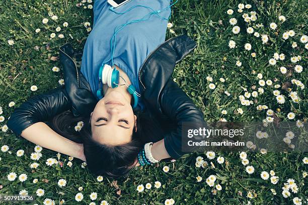 teenage girl lying down in the grass - girl lying down stock pictures, royalty-free photos & images