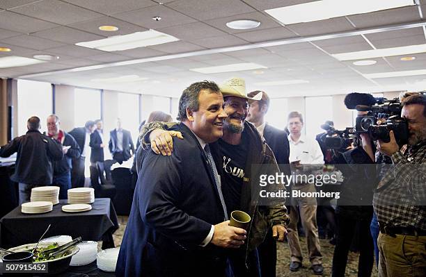 Chris Christie, governor of New Jersey and 2016 Republican presidential candidate, left, stands for a photograph with a supporter after speaking...