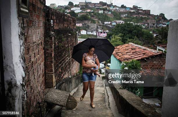 David Henrique Ferreira, 5 months, who was born with microcephaly, is carried by his mother Mylene Helena Ferreira up the stairs back to their home...