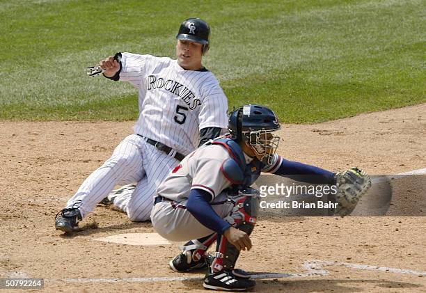 Matt Holliday of the Colorado Rockies slides home before catcher Johnny Estrada of the Atlanta Braves can make the tag on a double by pinch hitter...