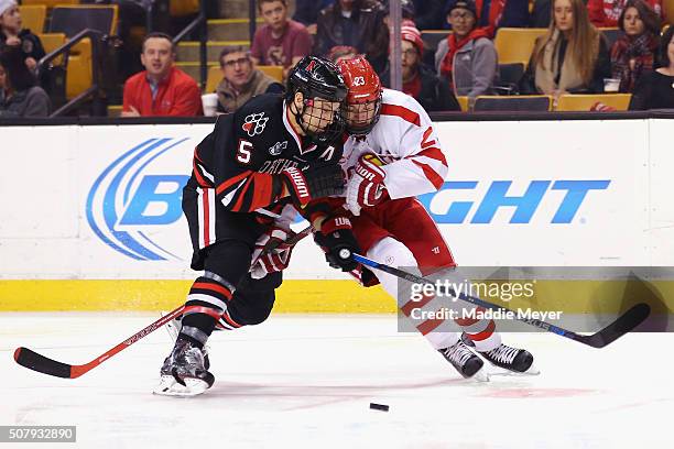 Matt Benning of the Northeastern Huskies and Jakob Forsbacka Karlsson of the Boston University Terriers battle for the puck during the third period...