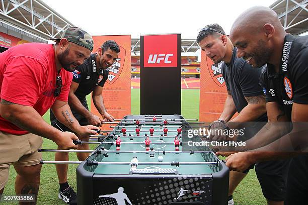 Fighters Mark Hunt and Frank Mir play foosball with Brisbane Roar players Henrique and Jamie Young during a media opportunity at Suncorp Stadium on...