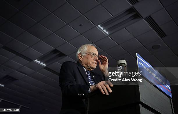 Democratic presidential candidate Sen. Bernie Sanders adjusts his eyeglasses as he speaks to supporters during a caucus night party February 1, 2016...