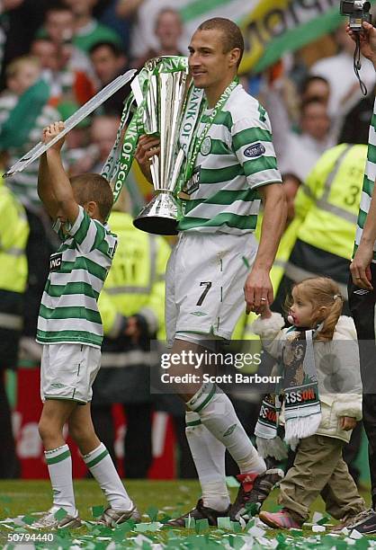 Celtic's Swedish striker Henrik Larsson does a lap of honour with his son and daughter after being presented with the Scottish Premier League Trophy...