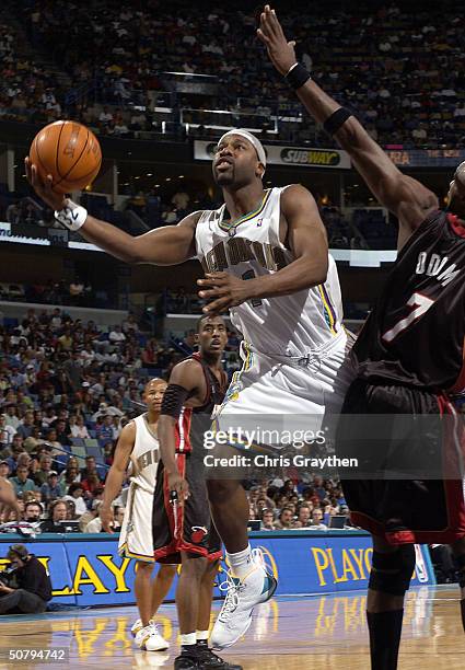 Baron Davis of the New Orleans Hornets drives for a shot attempt around Lamar Odom of the Miami Heat in Game Six of the Eastern Conference...